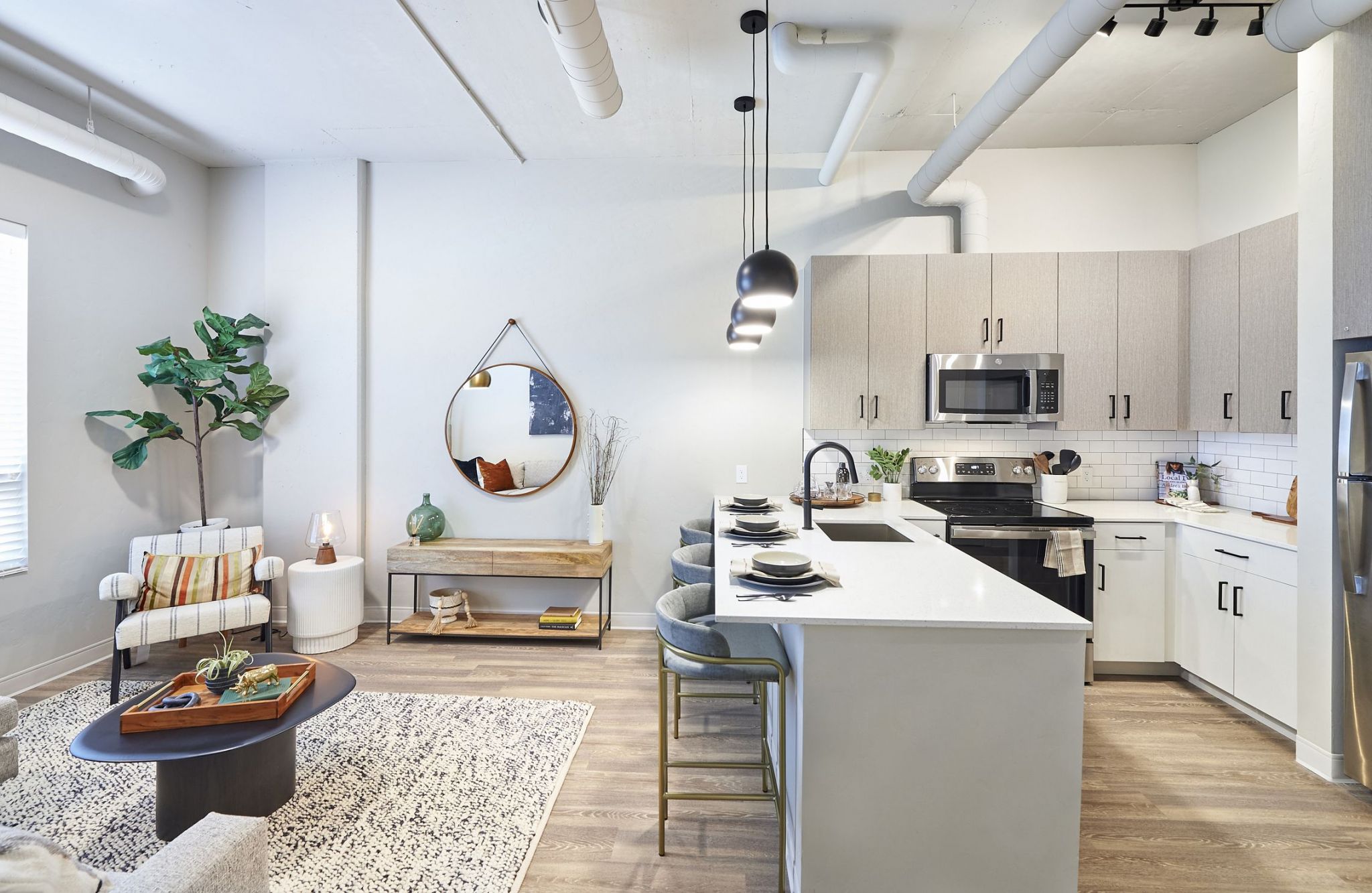 Modern, open-concept kitchen and living area with white countertops, stainless steel appliances, and cozy seating area. Perfect for experiencing the local Boise charm.