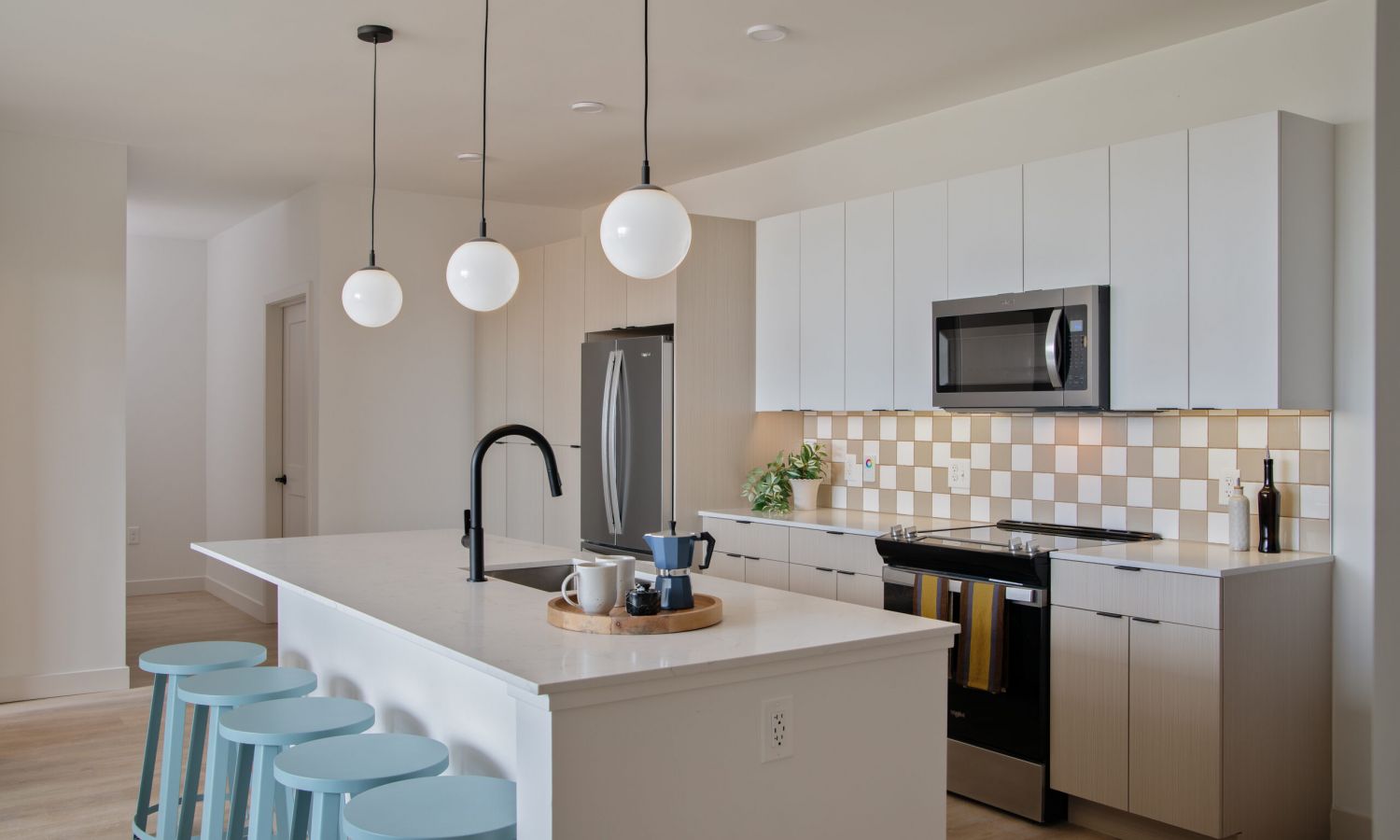 Modern, open-concept kitchen and living area with white countertops, stainless steel appliances, and cozy seating area. Perfect for experiencing the local Boise charm.