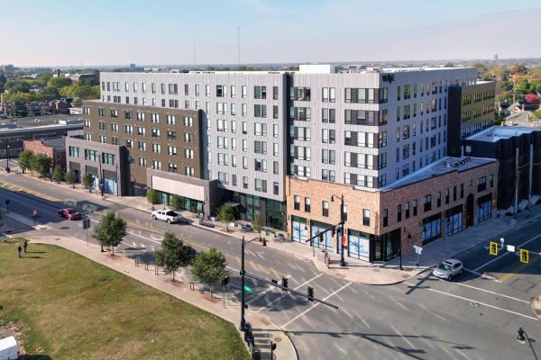 Aerial view of the VERVE Columbus, a modern multi-story apartment building complex at a street intersection on a sunny day.