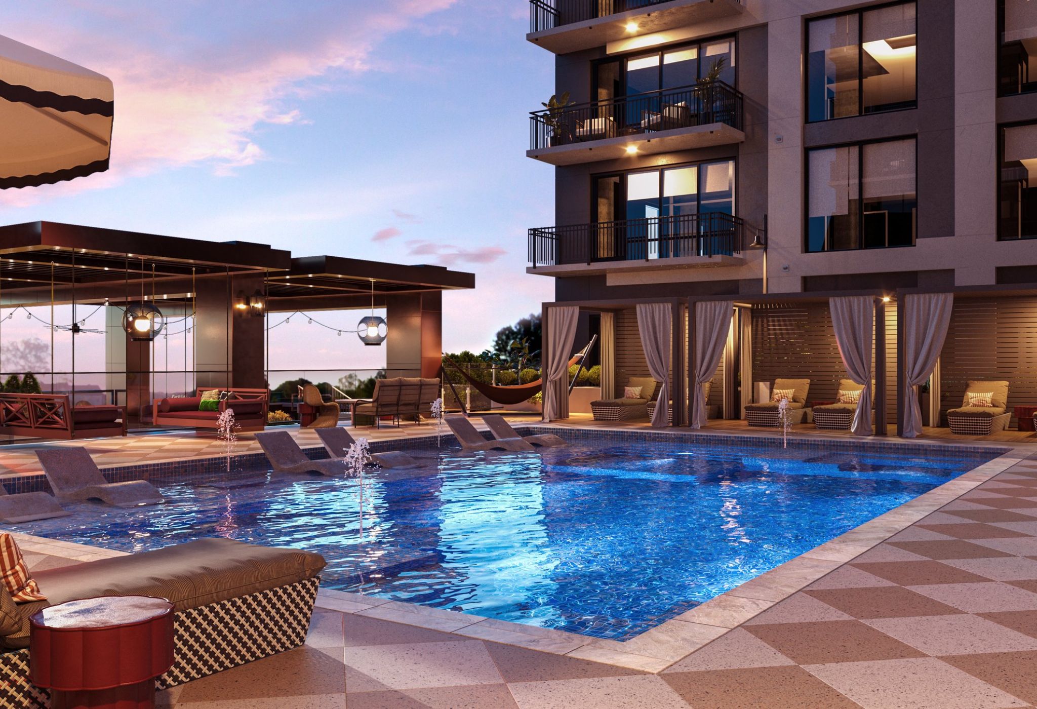 A luxurious outdoor pool area at dusk, featuring several lounge chairs partially submerged in the water. Private cabanas with curtains surround the pool, while a modern Nashville building with balconies overlooks the space. The sky is painted in soft hues of pink and purple.