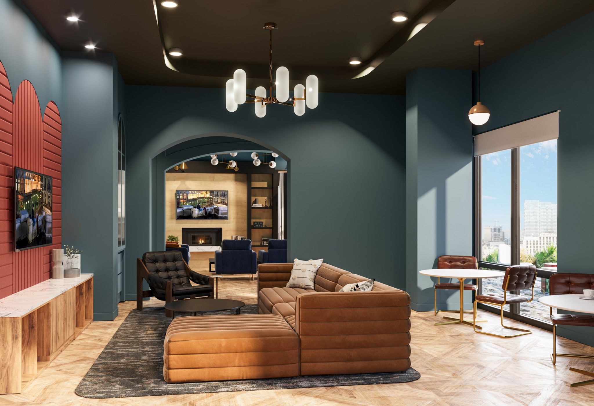 A modern living room features a brown sectional sofa with pillows, a black armchair, and large windows offering a cityscape view. A TV is mounted on a brick accent wall, and contemporary lighting fixtures hang from the dark ceiling. Light wood flooring adds warmth.